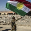 Kurdish peshmerga fighters fly a Kurdish flag in the city of Sinjar, Iraq, Nov. 13, 2015. Deafening bursts of celebratory gunfire erupted after Yazidi fighters helped the Kurds gain control of the city Friday, which has been under the brutal domination of the Islamic State for more than 15 months. (Bryan Denton/The New York Times)
